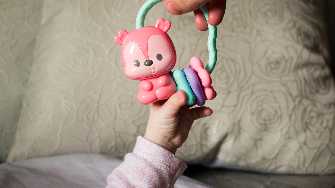 Rattle and reach – use a rattle to encourage your baby to adjust their movements - Featured Image