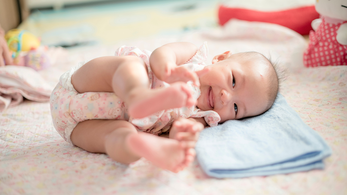 Placing your baby on their side for play can encourage rolling - Featured Image